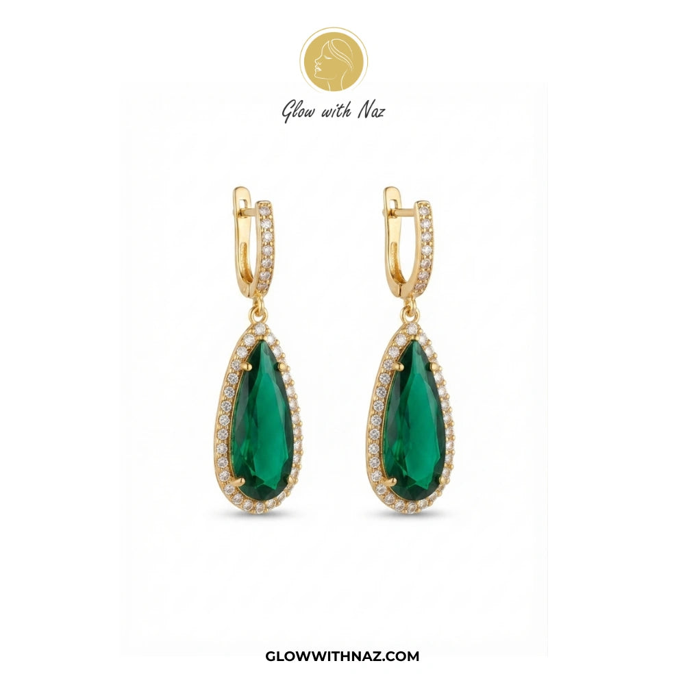 A pair of gold teardrop drop earrings with large green gemstones and small clear stones, shown on a white background with Glow with Naz branding. studs earrings, small earrings, girls earrings, simple earrings, earrings for girls, black earrings, earrings, ear rings, earrings tops, stud earrings, tops earrings, aesthetic earrings, hoop earrings, drop earrings, diamond earrings, pink earrings, green earrings, ear ring, earrings for women, flower earrings, golden earrings, bali earrings, ear jewellery, cute e