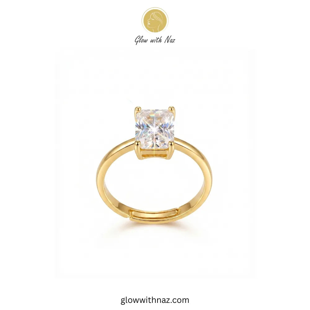 A gold solitaire ring with a square-cut clear gemstone, displayed on a clean white background with a brand logo 'Glow with Naz' at the top. ring, girls rings, rings for girls, rings simple, simple rings, stainless steel jewelry, jewellery set, aesthetic jewelry, simple jewellery, chain, jewelry, artificial jewellery