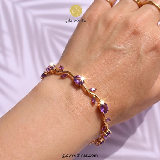 Gold bracelet with purple stones on a wrist against a white background Tulip Rapunzel bracelet, floral tulip bracelet, Rapunzel inspired jewelry, aesthetic tulip bracelet, trendy charm bracelet, stainless steel tulip bracelet, gold plated flower bracelet, delicate floral wrist accessory, cute aesthetic jewelry, viral tulip bracelet, Rapunzel theme accessories, dainty floral bracelet, crystal tulip charm, stacking bracelets for women, minimalist floral jewelry, spring aesthetic bracelet, elegant tulip wristb