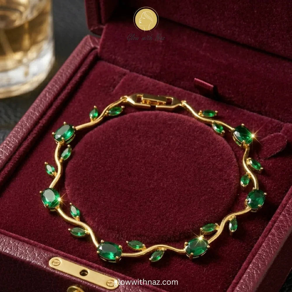 A gold bracelet with green gemstones arranged in a vine pattern, displayed inside a dark red velvet jewelry box. Tulip Rapunzel bracelet, floral tulip bracelet, Rapunzel inspired jewelry, aesthetic tulip bracelet, trendy charm bracelet, stainless steel tulip bracelet, gold plated flower bracelet, delicate floral wrist accessory, cute aesthetic jewelry, viral tulip bracelet, Rapunzel theme accessories, dainty floral bracelet, crystal tulip charm, stacking bracelets for women, minimalist floral jewelry, sprin