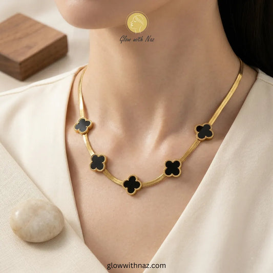 18K Gold Snake Chain with Five-Motif Black Clovers Necklace Pink tulip Necklace with pink stones on a white plate, brand 'Glow with Naz' visible