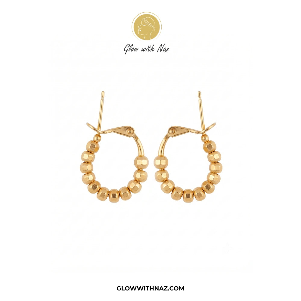A pair of gold hoop earrings with a beaded outer rim, shown on a plain white background with Glow with Naz branding above and the website at the bottom. studs earrings, small earrings, girls earrings, simple earrings, earrings for girls, black earrings, earrings, ear rings, earrings tops, stud earrings, tops earrings, aesthetic earrings, hoop earrings, drop earrings, diamond earrings, pink earrings, green earrings, ear ring, earrings for women, flower earrings, golden earrings, bali earrings, ear jewellery,