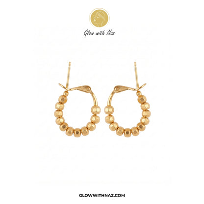 A pair of gold hoop earrings with a beaded outer rim, shown on a plain white background with Glow with Naz branding above and the website at the bottom. studs earrings, small earrings, girls earrings, simple earrings, earrings for girls, black earrings, earrings, ear rings, earrings tops, stud earrings, tops earrings, aesthetic earrings, hoop earrings, drop earrings, diamond earrings, pink earrings, green earrings, ear ring, earrings for women, flower earrings, golden earrings, bali earrings, ear jewellery,