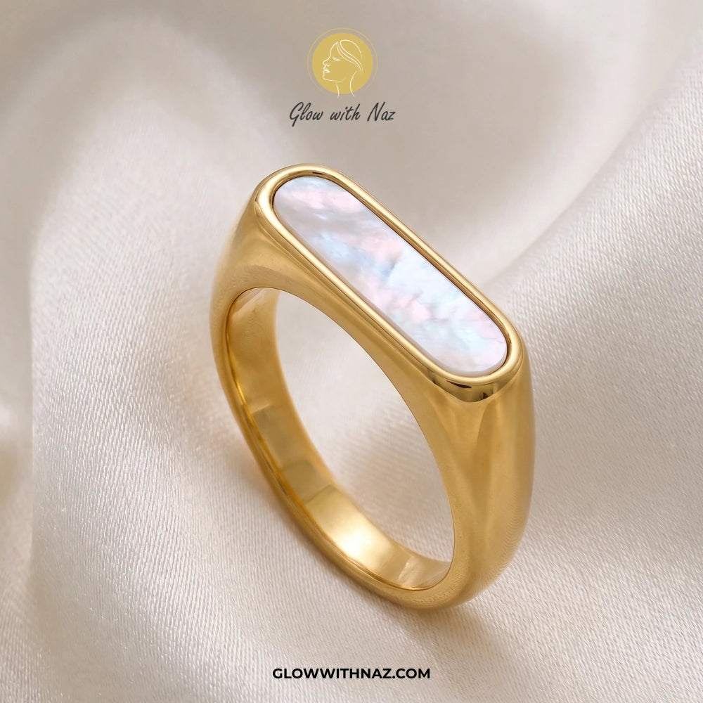 Gold ring with a central stone on a soft fabric background, featuring 'Glow with Naz' branding. ring gold, rings gold, gold rings, ring design, gold ring, ring, rings design, girls rings, rings for girls, gold ring price in pakistan, rings simple, simple rings, gold ring design, ring design gold, ring gold design, rings for women, black ring, rings gold design, gold rings design, aesthetic rings, ring designs, girls ring, elden ring, finger ring, rings, engagement rings gold, ring for girls, gold rings desi