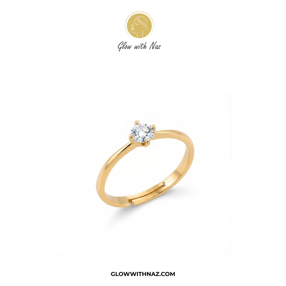 A yellow gold solitaire ring with a round-cut clear gemstone, displayed on a clean white background with the brand logo 'Glow with Naz' at the top and the website 'GLOWWITHNAZ.COM' at the bottom.

ring, girls rings, rings for girls, rings simple, simple rings, stainless steel jewelry, jewellery set, aesthetic jewelry, simple jewellery, chain, jewelry, artificial jewellery