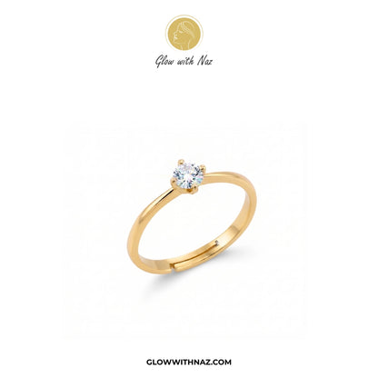 A yellow gold solitaire ring with a round-cut clear gemstone, displayed on a clean white background with the brand logo 'Glow with Naz' at the top and the website 'GLOWWITHNAZ.COM' at the bottom.

ring, girls rings, rings for girls, rings simple, simple rings, stainless steel jewelry, jewellery set, aesthetic jewelry, simple jewellery, chain, jewelry, artificial jewellery
