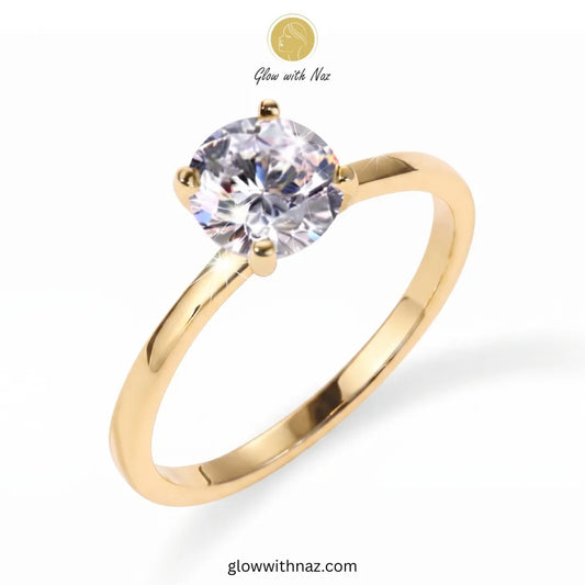 A yellow gold solitaire engagement ring with a round brilliant-cut clear gemstone, shown on a white background with a 'Glow with Naz' logo overlay. ring, girls rings, rings for girls, rings simple, simple rings, stainless steel jewelry, jewellery set, aesthetic jewelry, simple jewellery, chain, jewelry, artificial jewellery