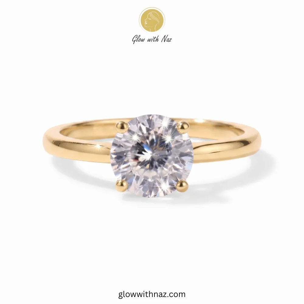 A yellow gold solitaire ring with a round brilliant-cut clear gemstone, shown on a white background with 'Glow with Naz' branding at the top. ring, girls rings, rings for girls, rings simple, simple rings, stainless steel jewelry, jewellery set, aesthetic jewelry, simple jewellery, chain, jewelry, artificial jewellery