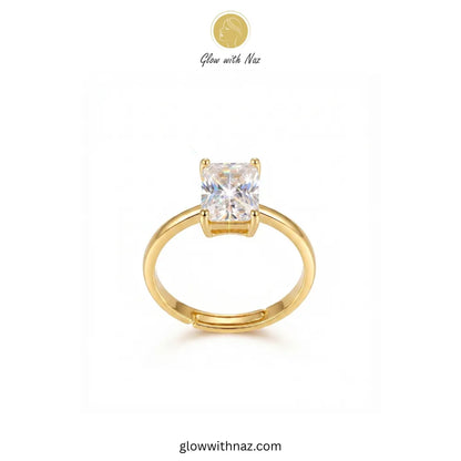 A gold solitaire ring with a square-cut clear gemstone, displayed on a clean white background with a brand logo 'Glow with Naz' at the top. ring, girls rings, rings for girls, rings simple, simple rings, stainless steel jewelry, jewellery set, aesthetic jewelry, simple jewellery, chain, jewelry, artificial jewellery