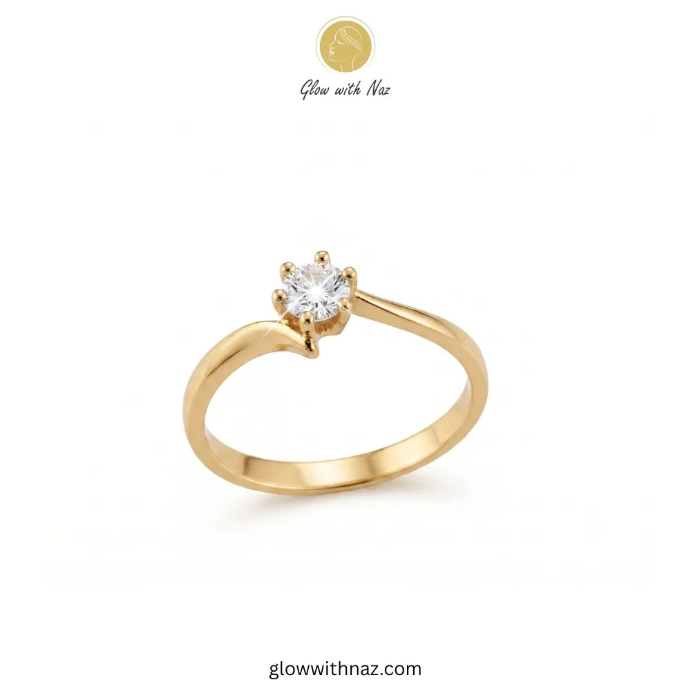 A yellow gold solitaire engagement ring with a round-cut clear gemstone in a prong setting, shown on a plain white background with Glow with Naz branding. ring, girls rings, rings for girls, rings simple, simple rings, stainless steel jewelry, jewellery set, aesthetic jewelry, simple jewellery, chain, jewelry, artificial jewellery 