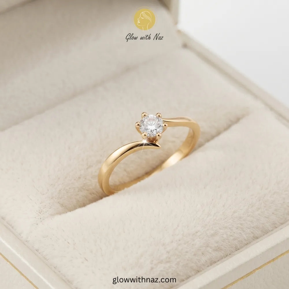 A gold solitaire engagement ring with a round-cut clear gemstone, displayed in a cream-colored velvet ring box. The brand logo 'Glow with Naz' is visible at the top and the website 'glowwithnaz. ring, girls rings, rings for girls, rings simple, simple rings, stainless steel jewelry, jewellery set, aesthetic jewelry, simple jewellery, chain, jewelry, artificial jewellery