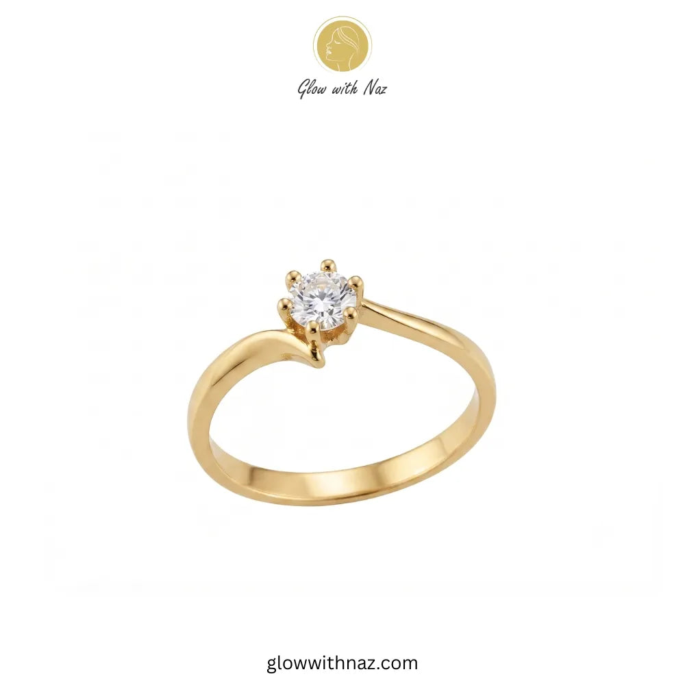 A yellow gold solitaire ring with a round-cut clear gemstone in a four-prong setting, shown on a plain white background with Glow with Naz branding at the top. ring, girls rings, rings for girls, rings simple, simple rings, stainless steel jewelry, jewellery set, aesthetic jewelry, simple jewellery, chain, jewelry, artificial jewellery