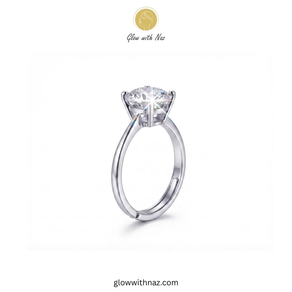 A silver solitaire engagement ring with a round brilliant-cut diamond center stone, shown on a plain white background with the brand logo 'Glow with Naz' at the top. ring, girls rings, rings for girls, rings simple, simple rings, stainless steel jewelry, jewellery set, aesthetic jewelry, simple jewellery, chain, jewelry, artificial jewellery