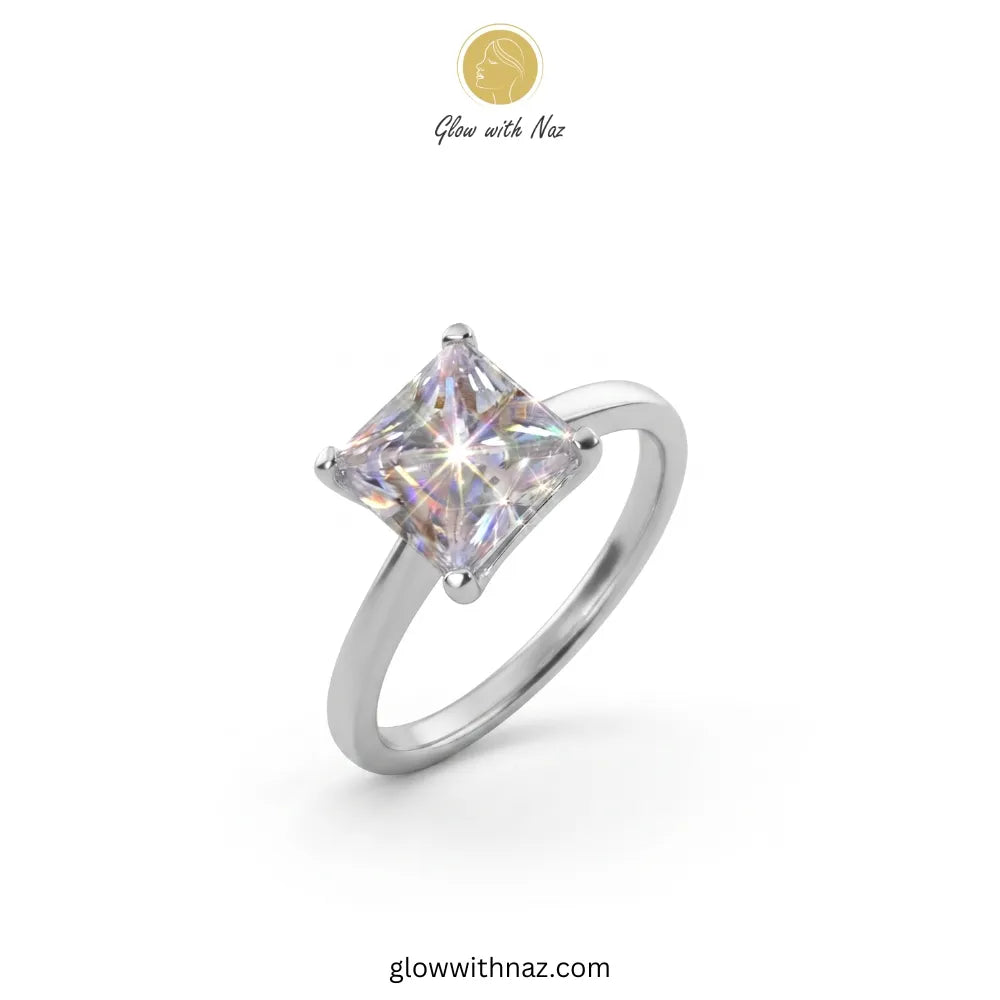 A silver-toned ring with a square iridescent gemstone, shown on a plain white background with a small 'Glow with Naz' logo at the top and the website at the bottom ring, girls rings, rings for girls, rings simple, simple rings, stainless steel jewelry, jewellery set, aesthetic jewelry, simple jewellery, chain, jewelry, artificial jewellery