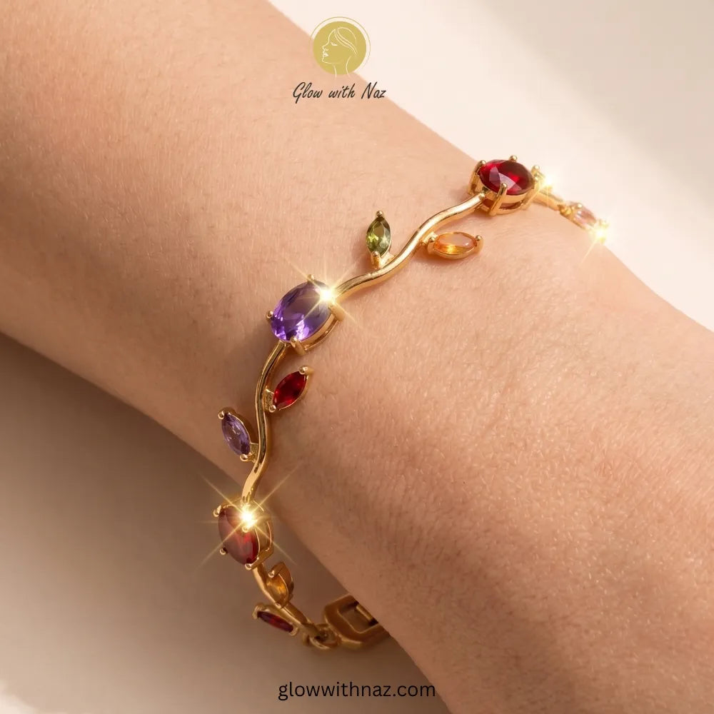 Gold bracelet with colorful gemstones on a wrist, branded 'Glow with Naz'. Tulip Rapunzel bracelet, floral tulip bracelet, Rapunzel inspired jewelry, aesthetic tulip bracelet, trendy charm bracelet, stainless steel tulip bracelet, gold plated flower bracelet, delicate floral wrist accessory, cute aesthetic jewelry, viral tulip bracelet, Rapunzel theme accessories, dainty floral bracelet, crystal tulip charm, stacking bracelets for women, minimalist floral jewelry, spring aesthetic bracelet, elegant tulip wr