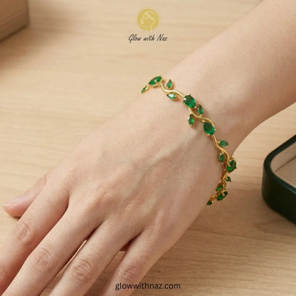 Gold bracelet with green gemstones on a wrist, brand 'Glow with Naz' visible Tulip Rapunzel bracelet, floral tulip bracelet, Rapunzel inspired jewelry, aesthetic tulip bracelet, trendy charm bracelet, stainless steel tulip bracelet, gold plated flower bracelet, delicate floral wrist accessory, cute aesthetic jewelry, viral tulip bracelet, Rapunzel theme accessories, dainty floral bracelet, crystal tulip charm, stacking bracelets for women, minimalist floral jewelry, spring aesthetic bracelet, elegant tulip 