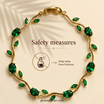 Gold vine-style bracelet with green marquise and oval stones, shown on a beige background with text reading 'Safety measures' and a perfume icon warning it should be kept away from perfume. Tulip Rapunzel bracelet, floral tulip bracelet, Rapunzel inspired jewelry, aesthetic tulip bracelet, trendy charm bracelet, stainless steel tulip bracelet, gold plated flower bracelet, delicate floral wrist accessory, cute aesthetic jewelry, viral tulip bracelet, Rapunzel theme accessories, dainty floral bracelet, crysta
