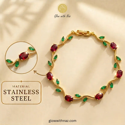 Gold-tone stainless steel bracelet with oval red gemstones and green leaf-shaped accents, shown on a beige background with a circular inset detail and text reading 'MATERIAL STAINLESS STEEL' and 'Glow with Naz'. Tulip Rapunzel bracelet, floral tulip bracelet, Rapunzel inspired jewelry, aesthetic tulip bracelet, trendy charm bracelet, stainless steel tulip bracelet, gold plated flower bracelet, delicate floral wrist accessory, cute aesthetic jewelry, viral tulip bracelet, Rapunzel theme accessories, dainty f