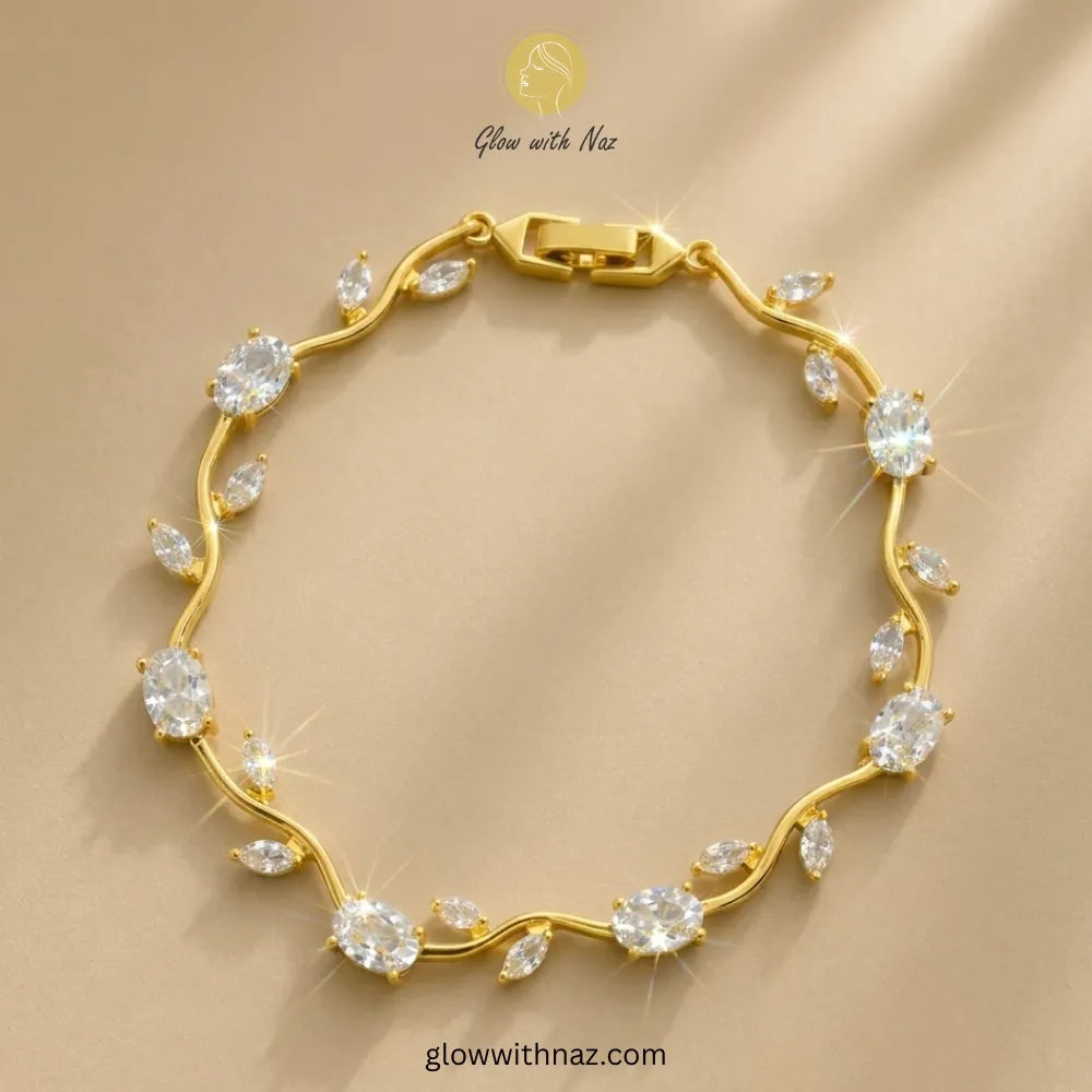 A gold bracelet with clear gemstones arranged along a wavy line, displayed on a beige background with a 'Glow with Naz' watermark. Tulip Rapunzel bracelet, floral tulip bracelet, Rapunzel inspired jewelry, aesthetic tulip bracelet, trendy charm bracelet, stainless steel tulip bracelet, gold plated flower bracelet, delicate floral wrist accessory, cute aesthetic jewelry, viral tulip bracelet, Rapunzel theme accessories, dainty floral bracelet, crystal tulip charm, stacking bracelets for women, minimalist flo