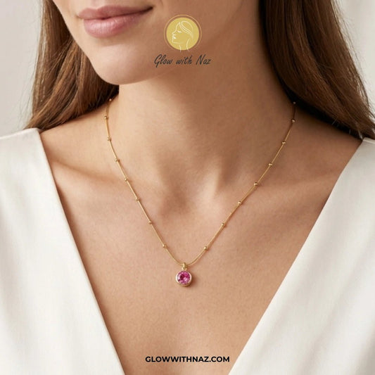Gold Plated Stainless Steel Beaded Chain Pink Pendant Necklace - Gold Plated Stainless Steel Beaded Chain Pink Pendant NecklaceJewelryGlow With NazGlow With NazGold necklace with a pink gemstone worn by a model, with 'Glow with Naz' branding. necklace, pendant necklace, necklace set, locket set, simple necklace, pendant set, pendant, chain necklace, diamond pendant, diamond necklace, locket necklace, neck chain, girls locket, heart locket, pendant for girls, necklace for girls, heart necklace, l